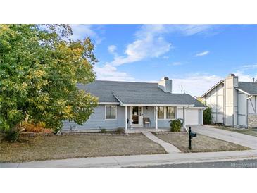 Charming single-story home featuring mature landscaping, a cozy front porch, and attached garage at 977 S Salida St, Aurora, CO 80017