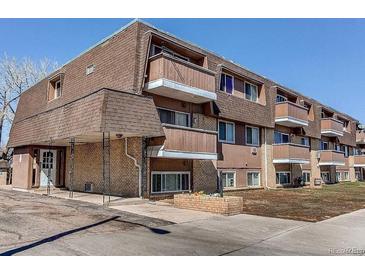 Multi-level condo building featuring brick facade, balconies, and a covered entrance at 561 E Geneva N St # 103, Aurora, CO 80010