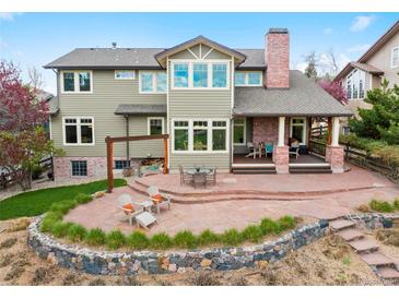 Expansive backyard featuring a stone patio, pergola, and outdoor seating, perfect for entertaining guests at 9 Amaranth Dr, Littleton, CO 80127