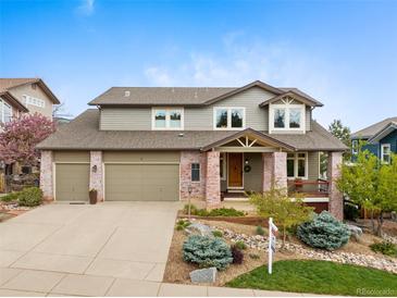 Charming two-story home with well-maintained landscaping, a brick facade, and a three-car garage at 9 Amaranth Dr, Littleton, CO 80127