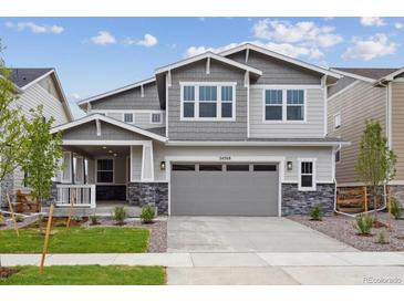 Charming two-story home with gray siding, stone accents, and a well-manicured front yard at 24768 E 40Th Ave, Aurora, CO 80019