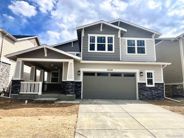 Charming two-story home with a covered porch, stone accents, and a spacious two-car garage at 24768 E 40Th Ave, Aurora, CO 80019