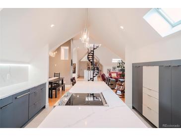 Bright kitchen features a large island with cooktop, pendant lighting, and an open layout with easy access to dining and living areas at 1165 N Pennsylvania St # 3B, Denver, CO 80203