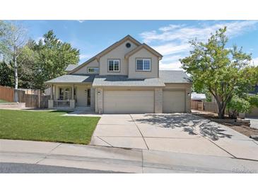 Two-story house with attached garage and landscaped lawn at 6858 Johnson St, Arvada, CO 80004