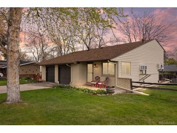 Charming single-story home with a well-manicured lawn, brick accents, and cozy front porch at 1000 Zang St, Golden, CO 80401