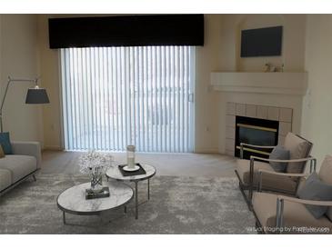 Bright living room featuring a fireplace, modern furniture, and a large sliding door with vertical blinds at 3220 Boulder Cir # 103, Broomfield, CO 80023