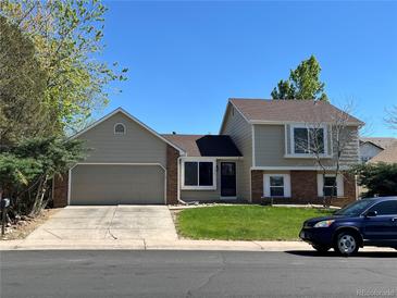 Charming two-story home with a manicured lawn and an attached two-car garage at 15962 E Exposition Dr, Aurora, CO 80017