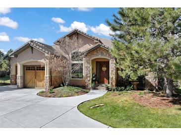 Charming home featuring a stone-accented entrance, arched doorway, and a well-manicured front yard at 5055 Mcclure Ln, Castle Rock, CO 80108