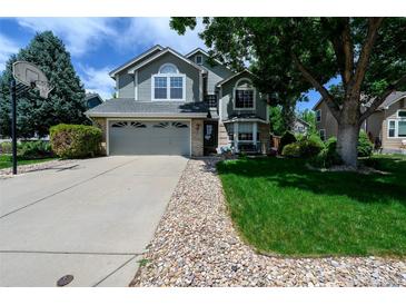 Charming two-story home with a well-maintained lawn, large tree and a driveway with a basketball hoop at 1387 Mcintosh Ave, Broomfield, CO 80020