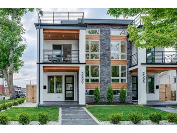 Modern two-story home with stone accents, balcony, and landscaped front yard at 2599 S Cherokee St, Denver, CO 80223