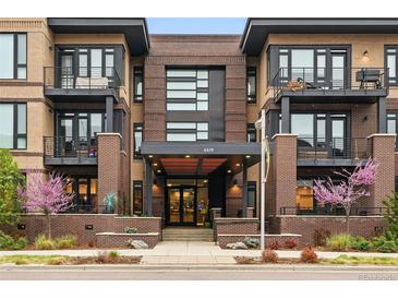 Inviting three-story condo building featuring brick facade, black accents, street-level landscaping and covered entry at 6619 E Lowry Blvd # 101, Denver, CO 80230