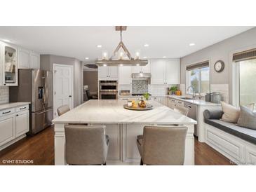 Spacious kitchen with an oversized island, stainless steel appliances, and a window bench seat at 9445 Aspen Hill Cir, Lone Tree, CO 80124