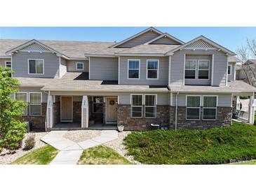 Charming townhome with stone accents, well-kept landscaping, and inviting front porches at 9758 Laredo St # 22D, Commerce City, CO 80022