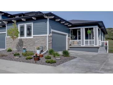 Charming two-story home with a gray exterior, stone accents, well-maintained landscaping, and inviting front porch at 527 Felicity Loop, Castle Rock, CO 80109