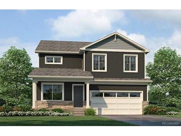 Charming two-story home with an attached two-car garage, stone accents and landscaped front yard at 9920 Biscay St, Commerce City, CO 80022