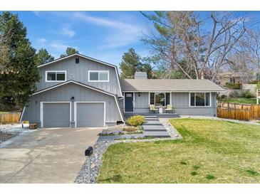 Charming two-story home with a well-maintained front yard, garage, and a cozy seating area on the front porch at 2477 S Dover Way, Lakewood, CO 80227