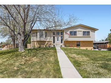 Charming two-story home with a well-manicured lawn and mature trees at 6477 W Clifton Pl, Littleton, CO 80128