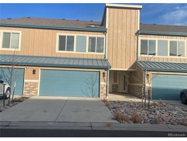 Modern two-story townhome featuring a blue two-car garage and neutral siding at 9642 E Idaho Pl, Aurora, CO 80247