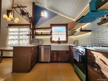 Bright kitchen with stainless steel appliances and unique wood cabinets at 3335 Dexter St, Denver, CO 80207