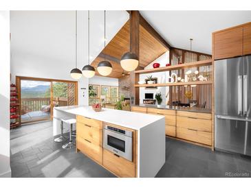 Bright, modern kitchen featuring a large island, stainless steel appliances, and mountain views at 1943 Columbine Ct, Golden, CO 80401