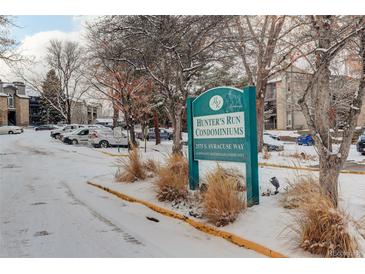 Hunter's Run Condominiums sign, snow covered entrance and parking lot at 2575 S Syracuse Way # 108, Denver, CO 80231