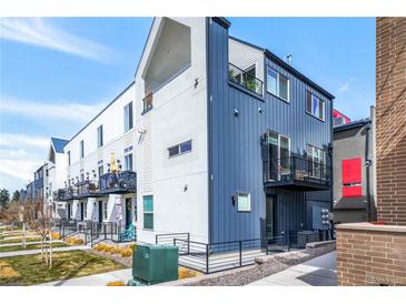 Modern townhome featuring a metal and stucco facade, multiple balconies, and well-maintained landscaping at 3050 Wilson Ct # 1, Denver, CO 80205