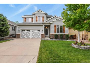 Charming two-story home featuring a well-manicured lawn, gray siding and a two car garage at 6471 S Potomac Ct, Englewood, CO 80111