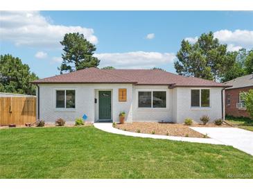 Charming home featuring a well-manicured lawn and a classic white brick exterior with a lovely brown roof at 2230 Niagara St, Denver, CO 80207