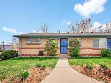 Charming brick home with a well-manicured lawn and a welcoming blue front door and walkway at 4201 Shoshone St, Denver, CO 80211