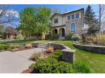 Charming stucco two-story home with stone accents and professionally landscaped front yard in a lush neighborhood at 1376 S Clayton St, Denver, CO 80210