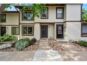 Charming townhouse with neutral siding, a dark front door, and a beautiful rock and garden landscape at 3571 S Kittredge St # C, Aurora, CO 80013