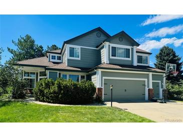 Charming two-story home boasts a manicured lawn, attached garage, and basketball hoop at 10421 Kennemere Ln, Parker, CO 80134