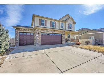 Home featuring a spacious driveway, a three-car garage, and a cozy covered porch at 18281 Keswick Ct, Parker, CO 80134