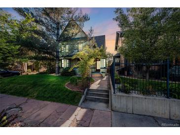 Inviting home featuring a well-maintained lawn, mature trees, and a charming walkway leading to the front door at 1057 N Emerson St # B, Denver, CO 80218