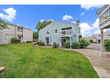 Charming blue townhouse with a well-manicured lawn and inviting curb appeal under a bright, sunny sky at 7917 Chase Cir # 160, Arvada, CO 80003