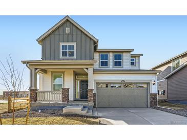 Charming two-story home showcasing a covered porch with stone accents and a neutral color palette at 4858 Astor Pl, Brighton, CO 80601