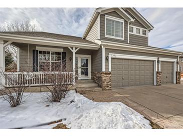 Two-story house with gray siding, a three-car garage, and a covered porch at 7395 Slate Ct, Castle Rock, CO 80108