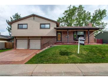 Charming two-story home featuring a brick and siding exterior, attached garage, and well-manicured front lawn at 10154 W Hawaii Pl, Lakewood, CO 80232