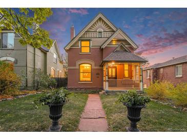 Charming two-story home with a well-manicured lawn and inviting front porch at twilight at 2841 N Franklin St, Denver, CO 80205