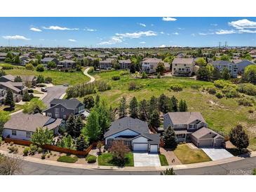 Lovely aerial view of neighborhood with mature landscaping and views of the Rocky Mountains at 1488 Baguette Dr, Castle Rock, CO 80108