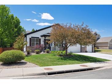 Traditional-style home with tidy landscaping, brick accents, and a spacious three-car garage at 1488 Baguette Dr, Castle Rock, CO 80108