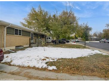 Cozy home featuring a brick facade and a mature tree in the front yard at 300 S Simms St, Lakewood, CO 80228