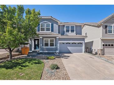 Charming two-story home with a well-maintained lawn, two-car garage, and covered front porch at 1963 Hogan Ct, Castle Rock, CO 80109