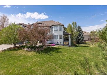 Elegant home featuring a well-manicured lawn and beautiful landscaping, creating a welcoming outdoor space at 9479 S Shadow Hill Cir, Lone Tree, CO 80124