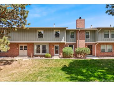 Charming two-story townhouse with red brick and green siding with manicured front lawn at 10208 E Jewell Ave # 18, Aurora, CO 80247