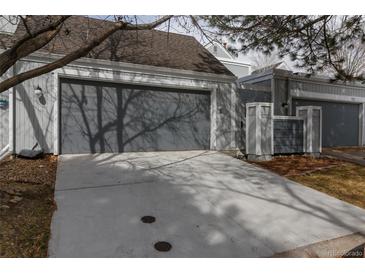Attached two-car garage featuring a concrete driveway with a grey door for a modern look at 2770 S Elmira St # 42, Denver, CO 80231