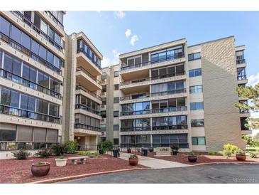 Exterior view of building with balconies, landscaping, and parking area with blue skies overhead at 13961 E Marina Dr # 414, Aurora, CO 80014
