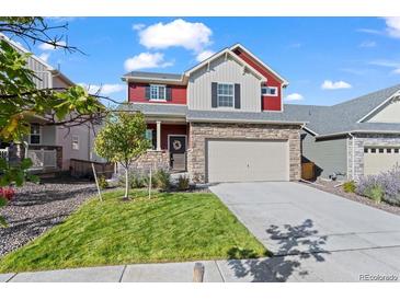 Charming two-story home with stone accents, a well-manicured lawn and an attached two car garage at 10909 Memphis Ct, Commerce City, CO 80022