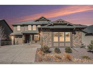 Charming two-story home with stone accents, landscaped yard, and inviting front porch at 8259 Arapahoe Peak St, Littleton, CO 80125