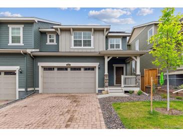 Inviting two-story home with a charming front porch, brick driveway, and attached two-car garage at 645 Flintwood Pl, Lafayette, CO 80026